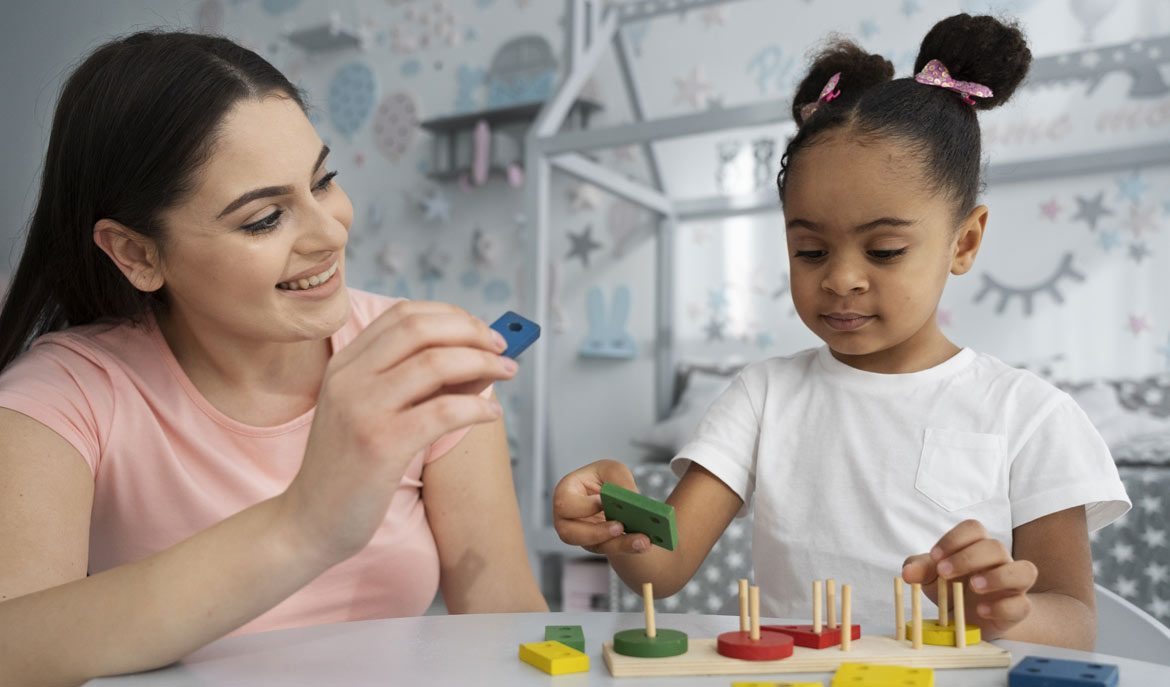 Child and mother interaction with wooden blocks. Qualities to Consider When Looking for an ABA Therapist, a blog from Positive Behavior Services