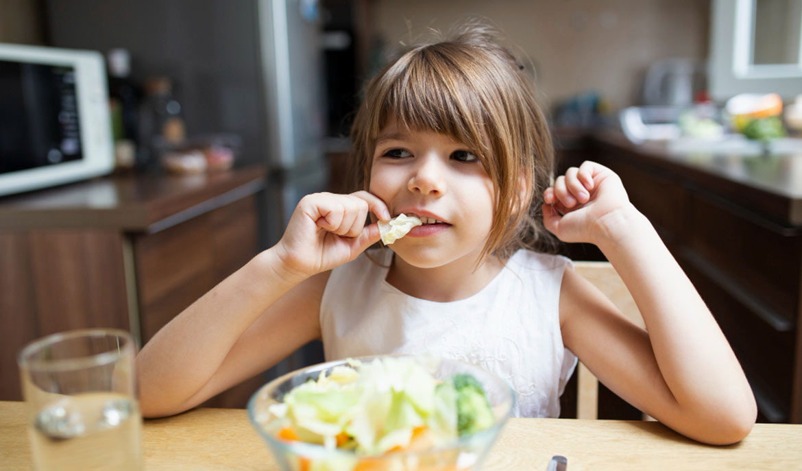Child eating at a table. Top Foods to Help with Concentration in Kids in ABA Therapy, a blog from Positive Behavior Services